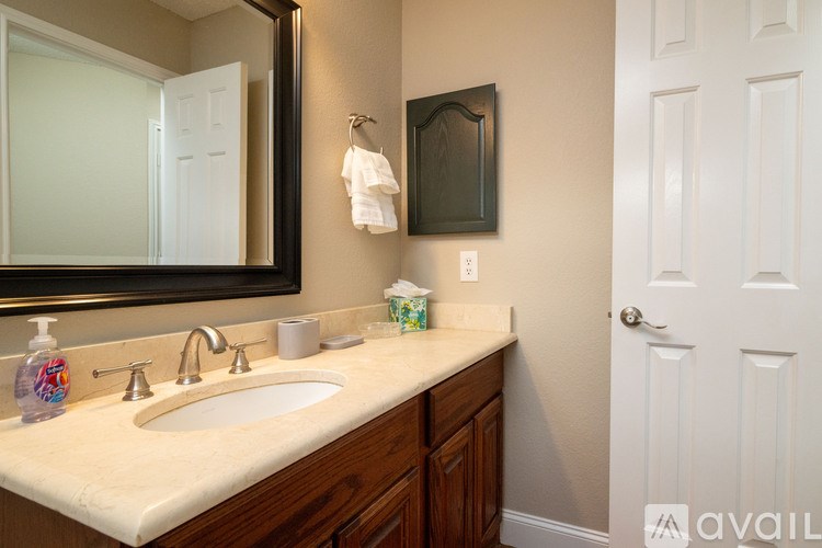 A bathroom with a sink, mirror, and a white door.