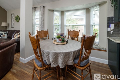 A dining room with a round table and chairs.