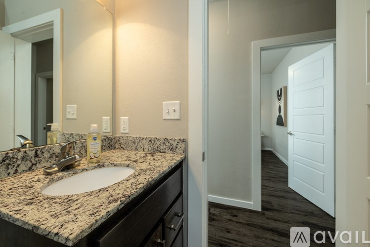 A bathroom with a granite countertop and a white door.