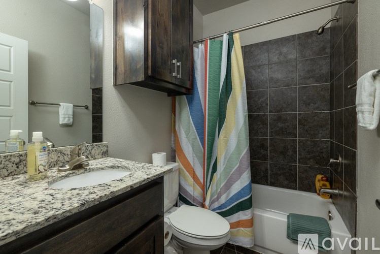 A bathroom with a toilet, sink, and a striped towel.