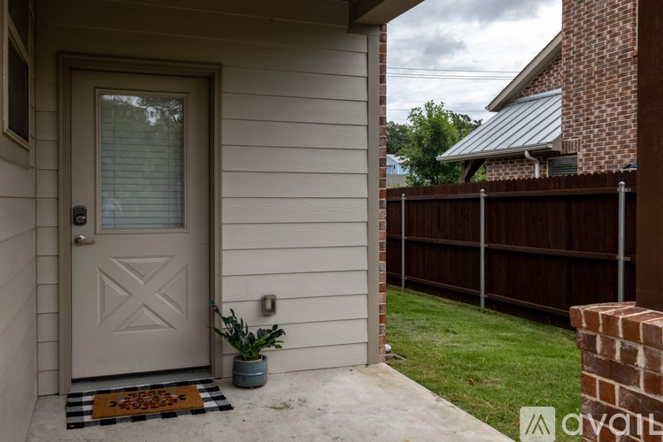 A house with a white door and a small plant on the porch.