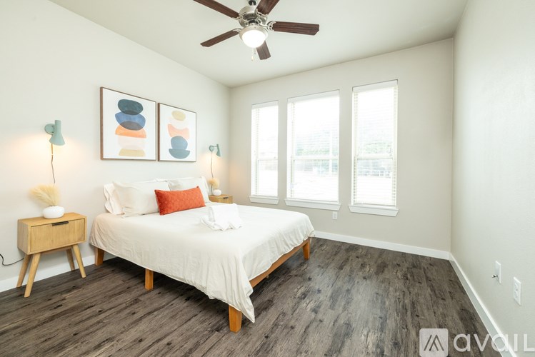 A bedroom with a bed, nightstand, and two wall lamps.
