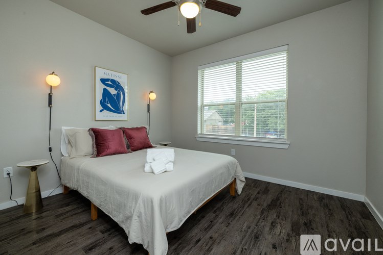 A bedroom with a bed, a ceiling fan, and a painting of a blue whale on the wall.