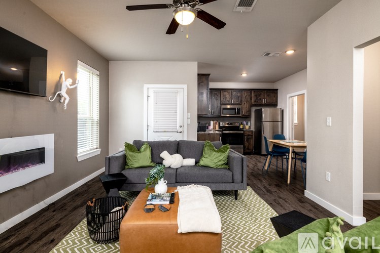 A living room with a grey couch and a television on the wall.