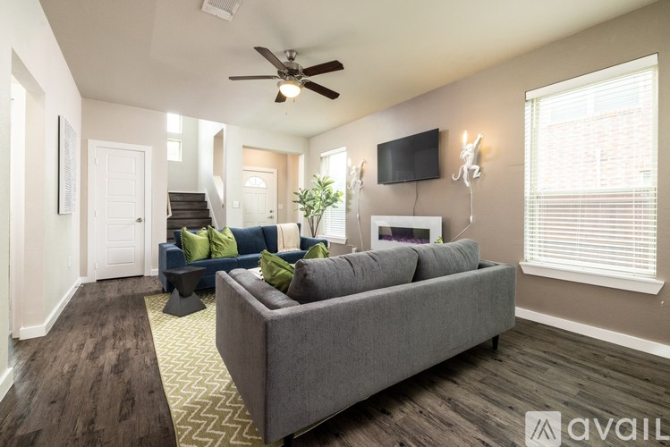 A living room with a grey couch and a ceiling fan.