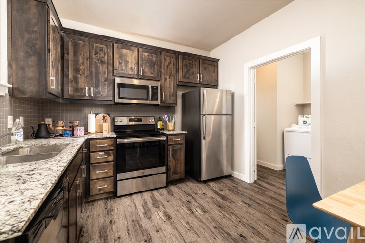 A kitchen with dark wood cabinets and stainless steel appliances.