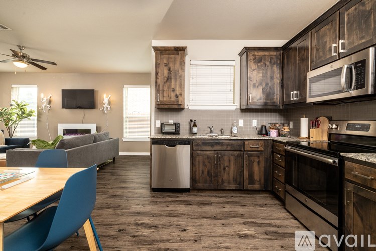 A kitchen with dark wood cabinets and a blue chair.