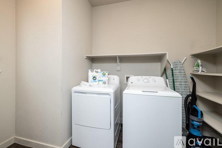 Two white front loading washing machines in a laundry room.
