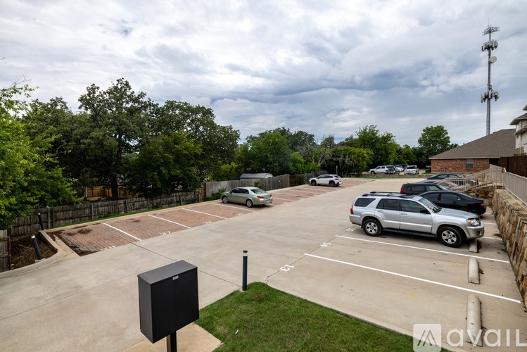 A parking lot with cars and a sign in the foreground.