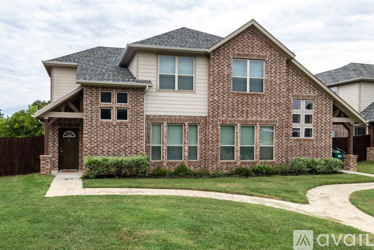 A house with a brick facade and a black door is for sale.