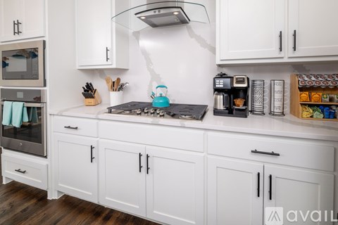 A kitchen with white cabinets and a black stove top.