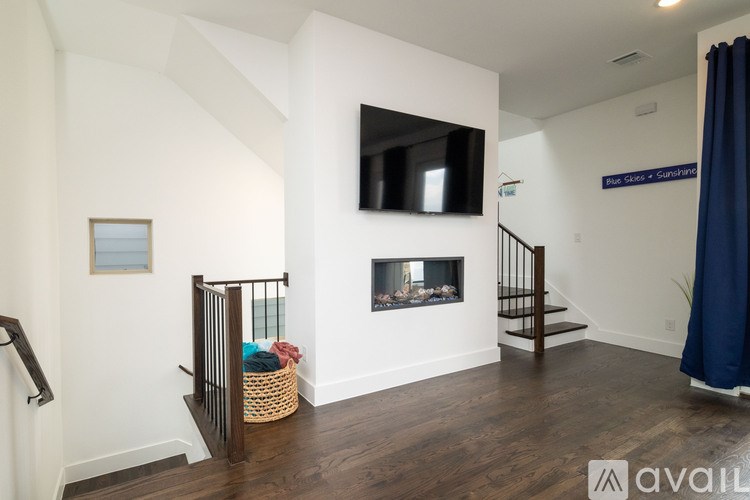 A living room with a fireplace and a flat screen TV mounted on the wall.