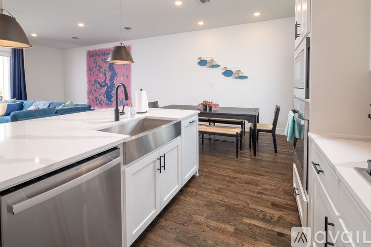 A modern kitchen with stainless steel appliances and wooden flooring.