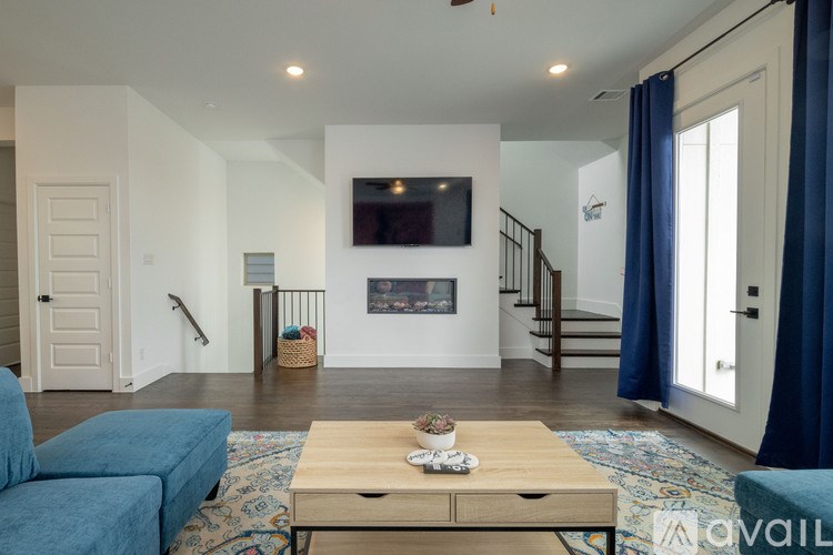 A living room with a blue couch and a wooden coffee table.