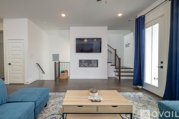 A living room with a blue couch and a wooden coffee table.