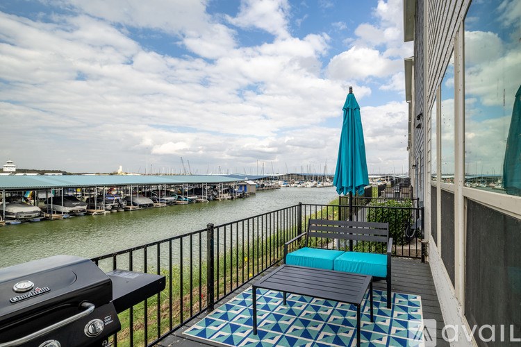 A balcony with a grill and a view of the water.