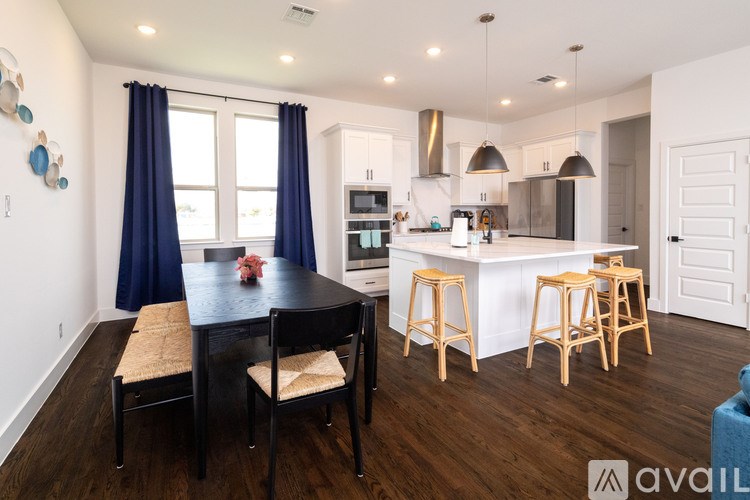 A kitchen with a table and chairs in front of a window.