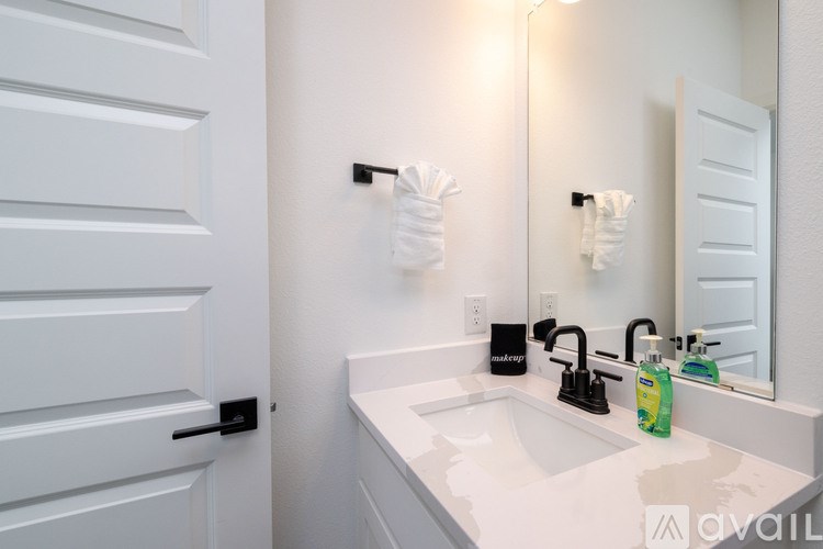 A white bathroom with a sink and a mirror.