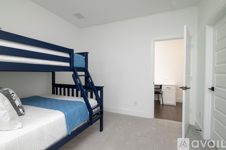 A bedroom with a bunk bed and a chair in the hallway.