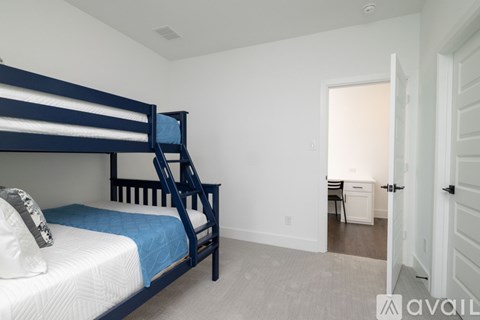 A bedroom with a bunk bed and a chair in the hallway.