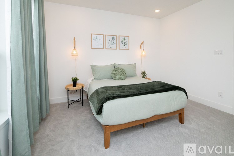 A bedroom with a bed, two lamps, and two framed pictures on the wall.