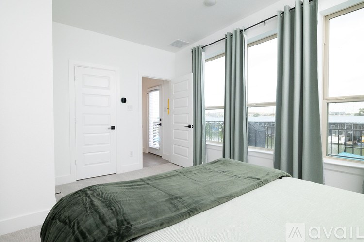 A bedroom with a large bed and a balcony.