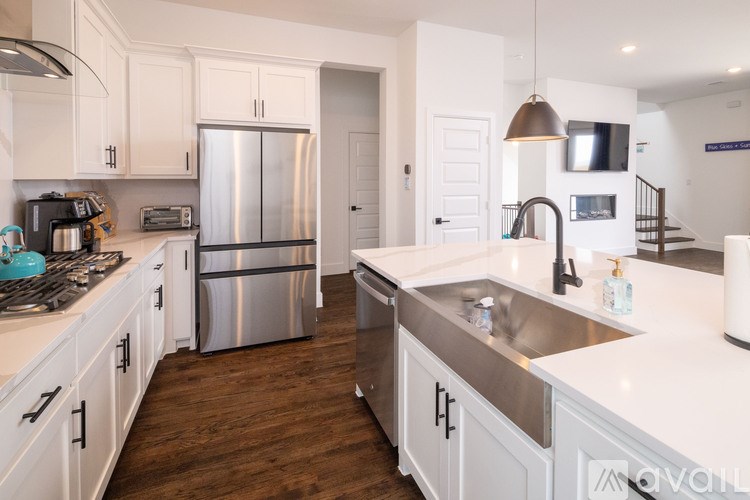 A kitchen with white cabinets and a stainless steel refrigerator.