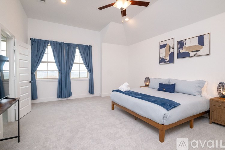 A bedroom with a bed, nightstand, and two pictures on the wall.