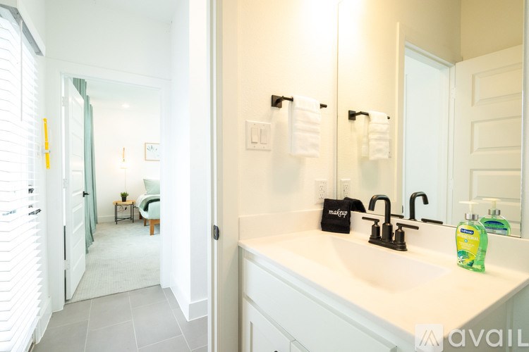 A bathroom with a white sink and a mirror.