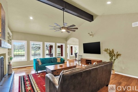 A living room with a green couch and a television mounted on the wall.