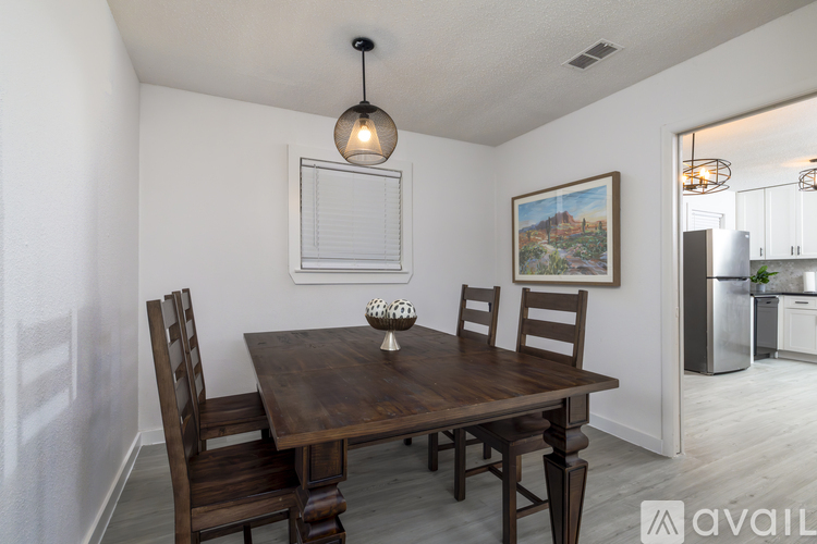 A dining room with a wooden table and chairs.