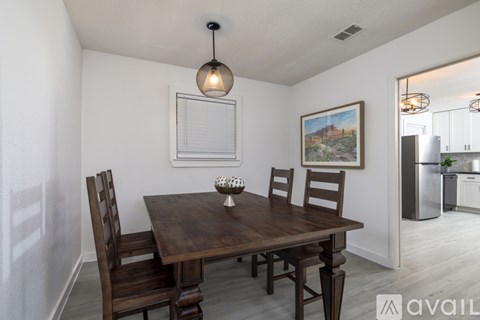 A dining room with a wooden table and chairs.