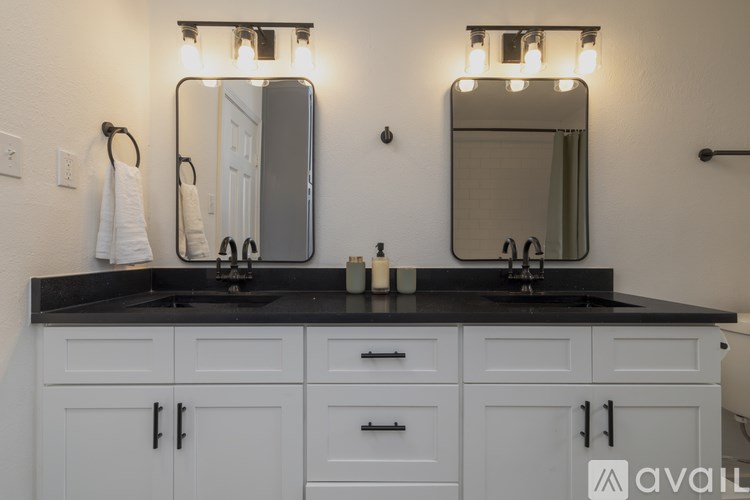 A bathroom vanity with two sinks and two mirrors.