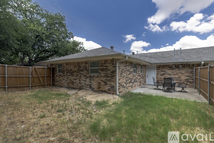 A house with a stone wall and a wooden fence.