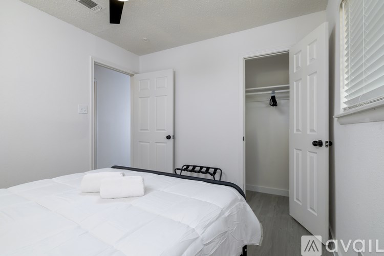 A bedroom with a bed, a bench, and a window.