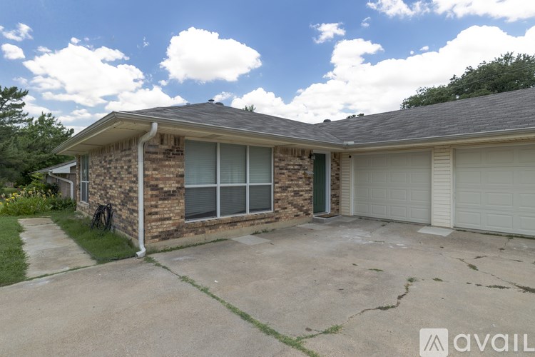 A house with a stone wall and a grey roof.