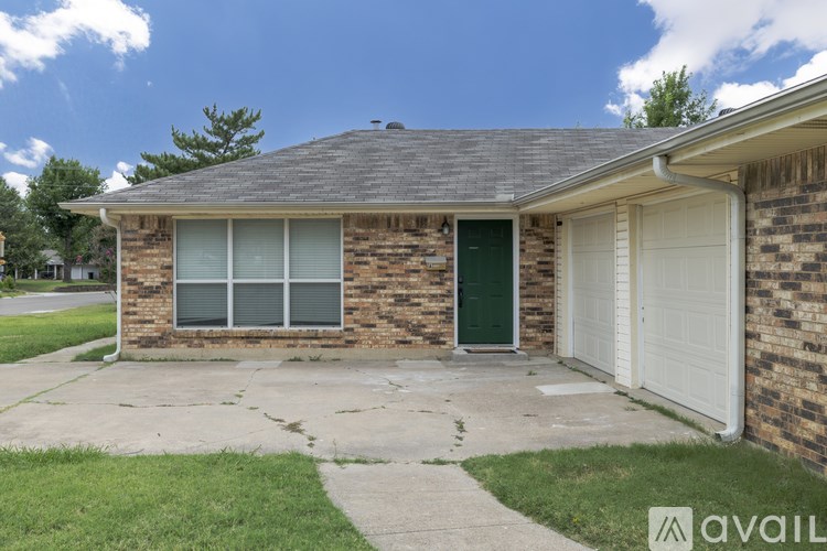 A house with a green door and a white garage door.