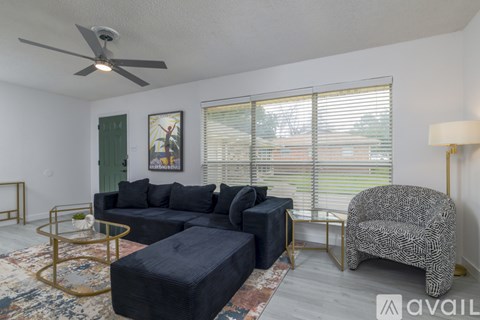 A living room with a black sofa and a patterned armchair.