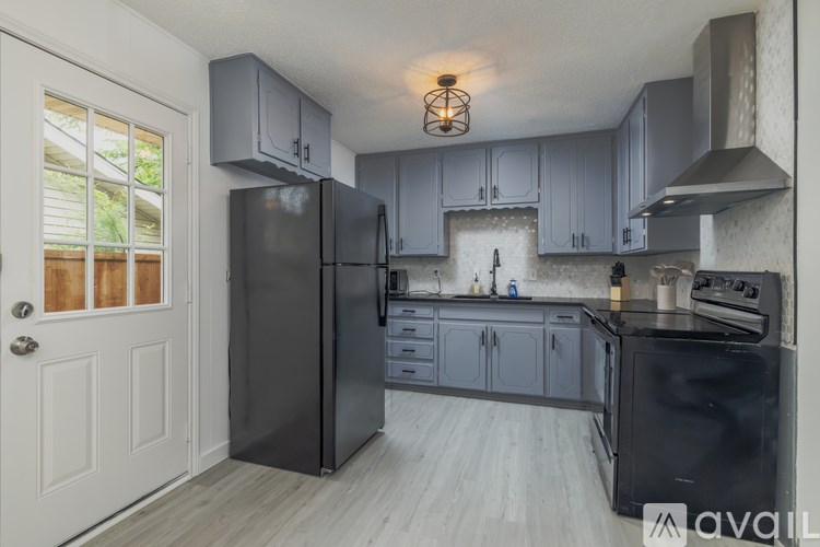 A kitchen with a black refrigerator and stove.