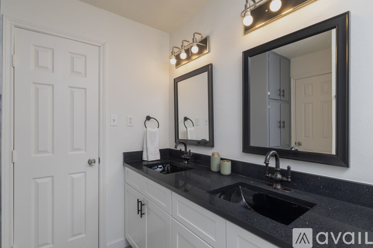 A bathroom with a sink, mirror, and lighting fixtures.
