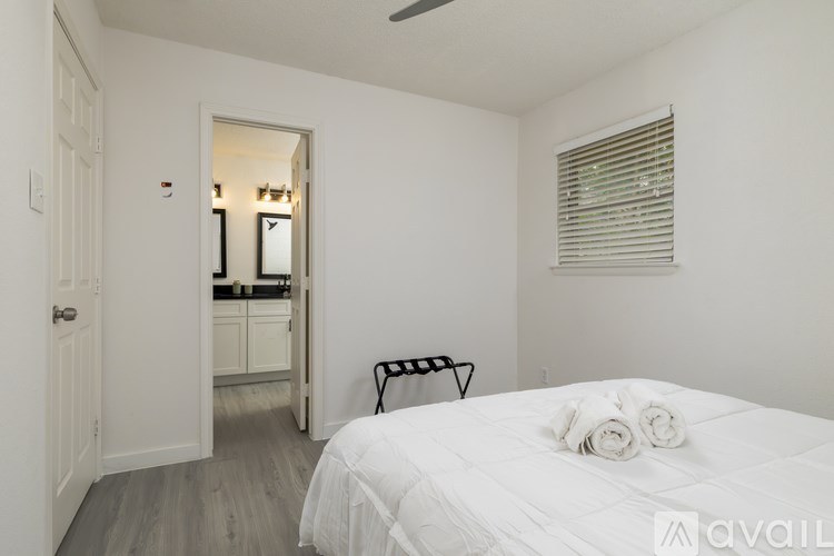 A bedroom with a bed, a chair, and a mirror.