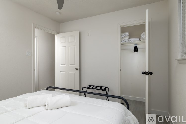 A bedroom with a bed, a chair, and a wardrobe.