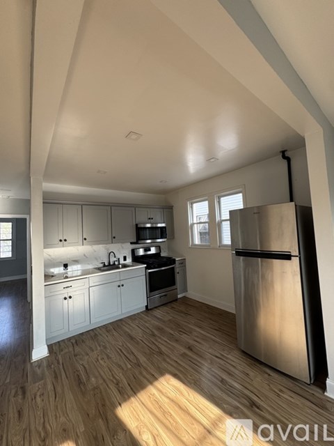 A kitchen with a refrigerator, sink, and cabinets.