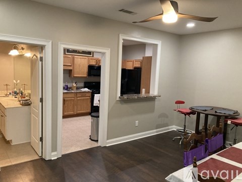 A kitchen with a dining table and chairs is visible through an open door.