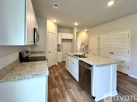 A kitchen with white cabinets and a granite countertop.