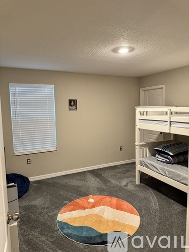 A room with a bunk bed and a window with blinds.