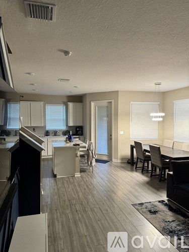 A modern kitchen with a dining area and a living room.