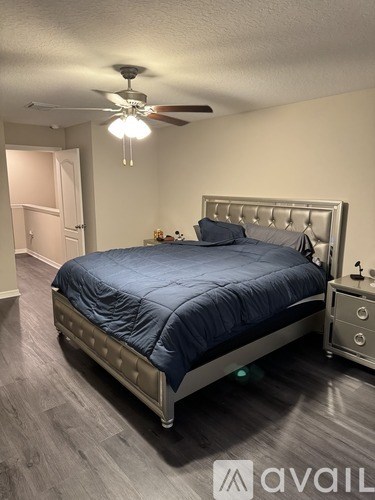 A bedroom with a bed, dresser, and ceiling fan.