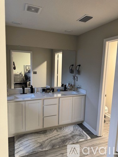 A bathroom with a double sink vanity and a large mirror.