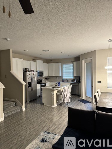 A modern kitchen with a dining table set for two.